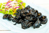 Stuffed squids in ink on a plate with lettuce and onions